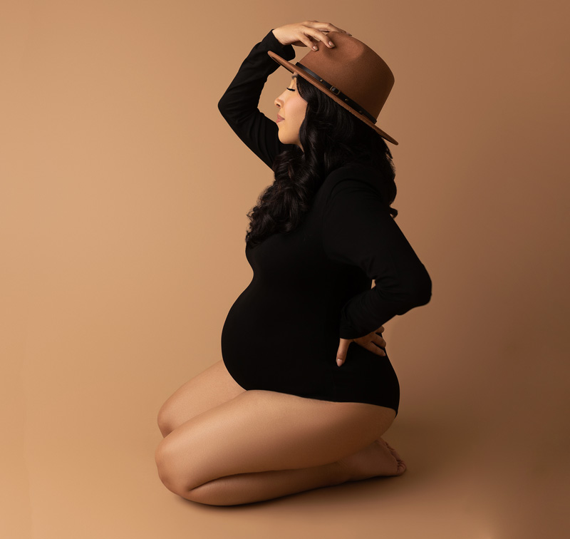 Mom to be on a brown backdrop captured by Austin maternity photographer.