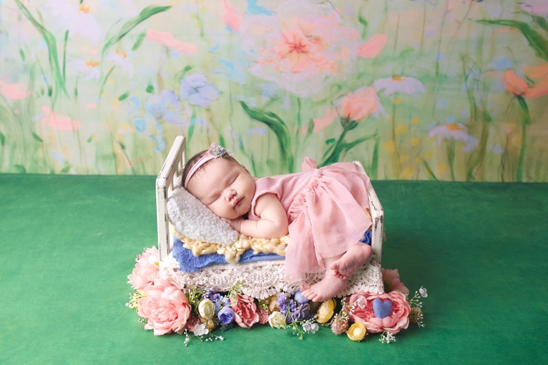 Baby on tiny bed, baby with flowers