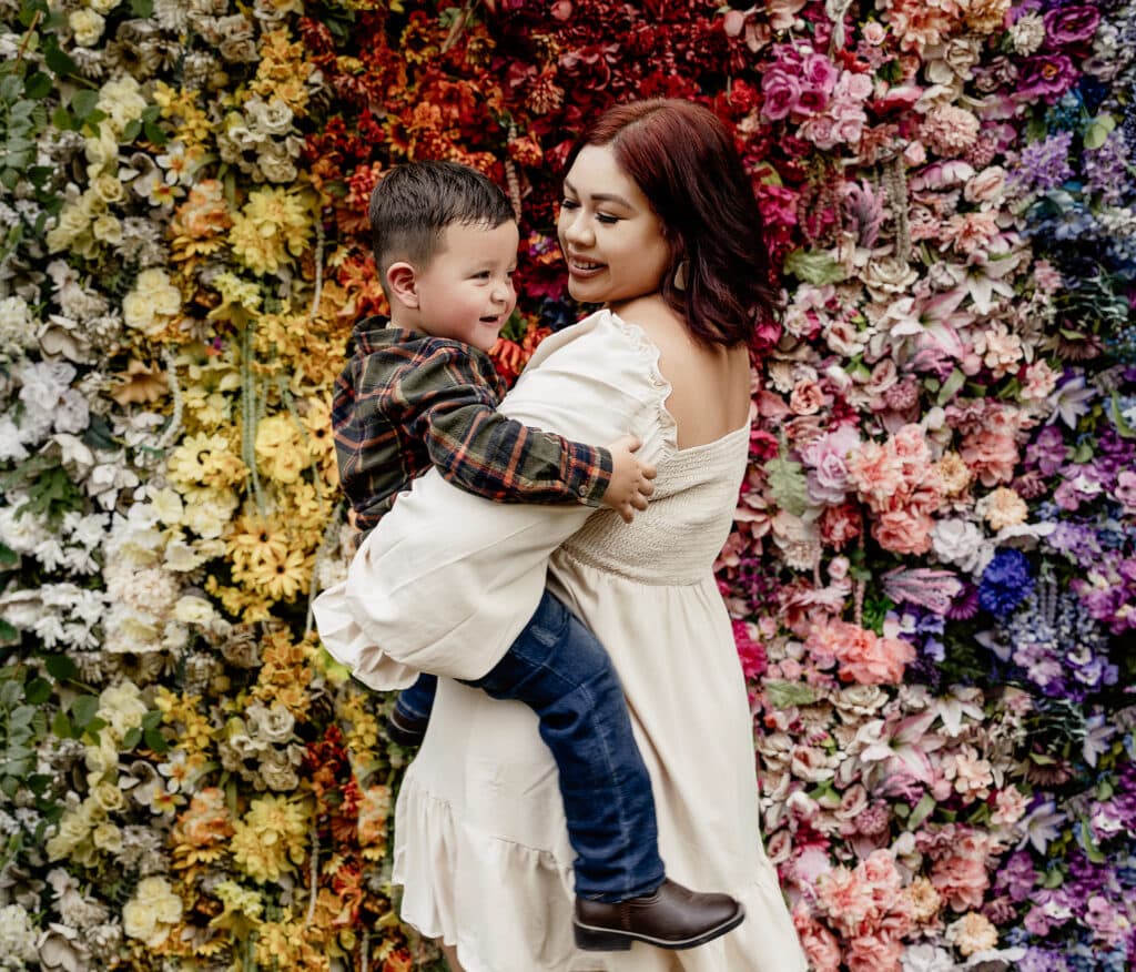 Mother and son portrait floral backdrop at a greenhouse in Austin, Texas.