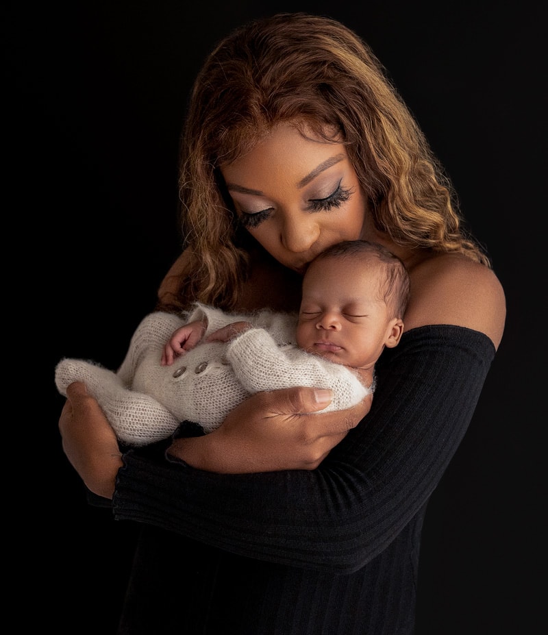 Mother holding her newborn baby boy captured by a newborn photographer in Texas.