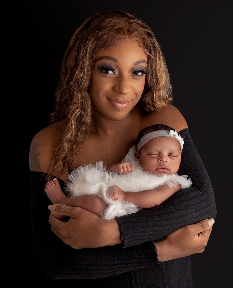 Mother hood portrait holding her newborn baby for newborn photoshoot.