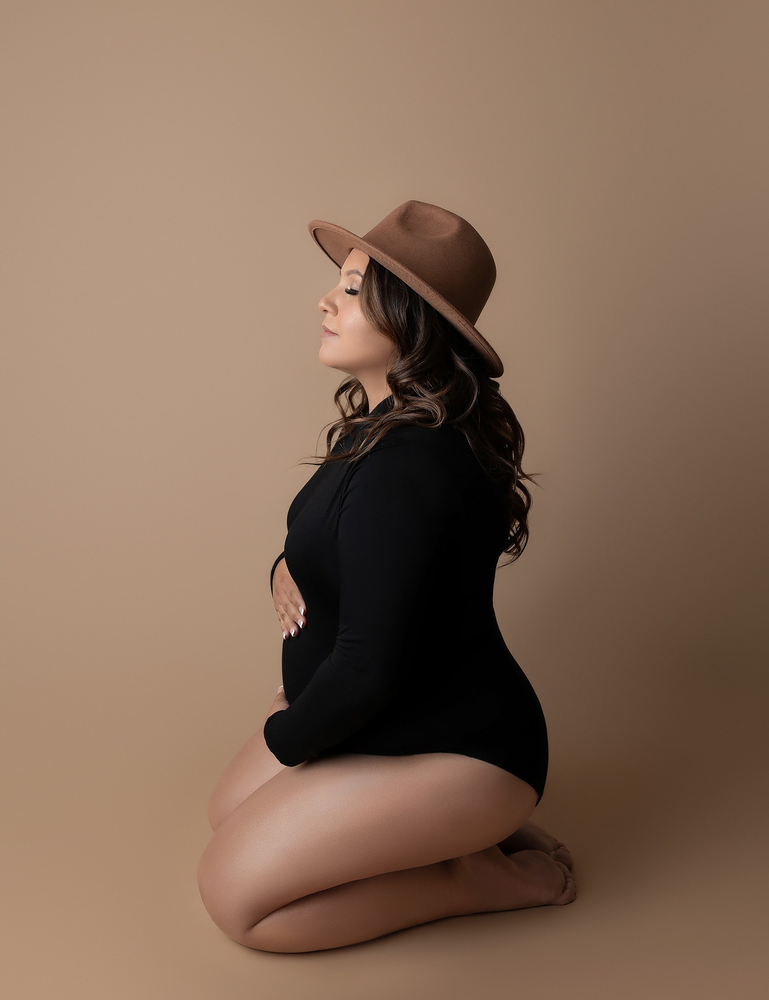 Mom to be holding her bump for her fine art portrait captured by Austin maternity photographer.
